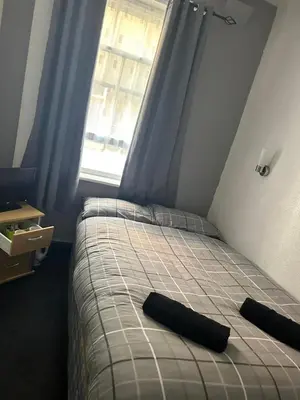 a bedroom with a bed with two black pillows on it at Adina Hotel in Blackpool