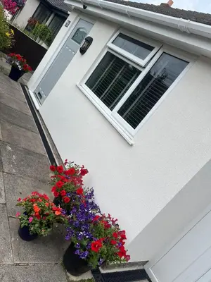 a white house with flowers in front of a window at Idyllic bungalow in Burscough, ideal location in West Lancashire in Burscough