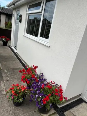 two pots of flowers in front of a house at Idyllic bungalow in Burscough, ideal location in West Lancashire in Burscough