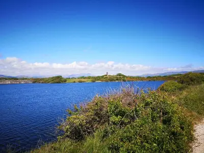a large body of water with trees and bushes at 136, Port Haverigg in Millom