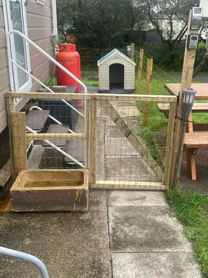 a chicken coop with a gate in a yard at 136, Port Haverigg in Millom