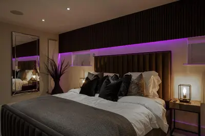 a bedroom with a large bed with purple lighting at Spengarth House by STAMP SA in Blackpool