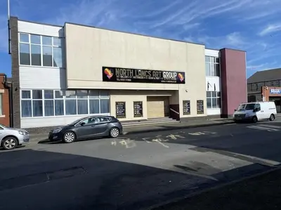 a building with two cars parked in front of it at ART APARTMENT in Fleetwood