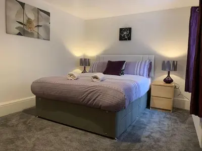 a bedroom with a large bed with two lamps on it at Newly renovated 4 bedroom house in Ulverston in Ulverston