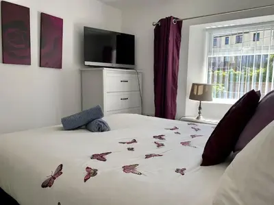 a bedroom with a white bed with butterflies on it at Newly renovated 4 bedroom house in Ulverston in Ulverston