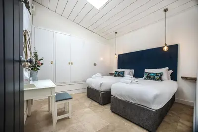 a hotel room with two beds and a desk at Bashall Barn in Clitheroe