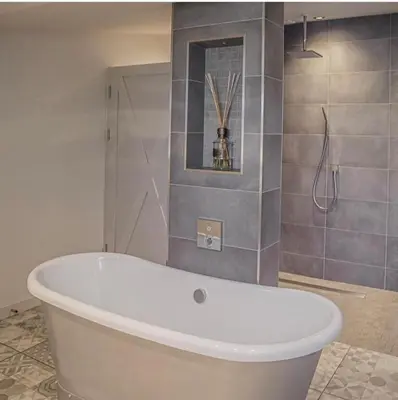 a white bath tub in a bathroom with a shower at Bashall Barn in Clitheroe