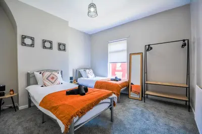 a bedroom with two beds and a mirror at Stay with Alexandra - Free Parking - Free Wifi Superb Location in Liverpool