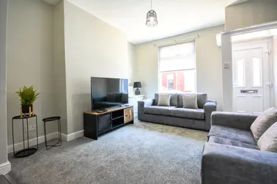 a living room with a couch and a flat screen tv at Stay with Alexandra - Free Parking - Free Wifi Superb Location in Liverpool