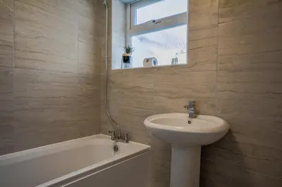 a bathroom with a sink and a bath tub and a mirror at Stay with Alexandra - Free Parking - Free Wifi Superb Location in Liverpool