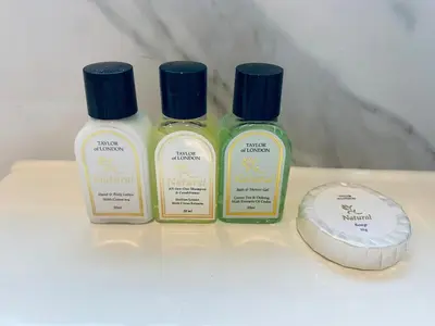 three bottles of moisturizers on a table next to a computer at The WhiteHouse Holiday Apartments in Blackpool