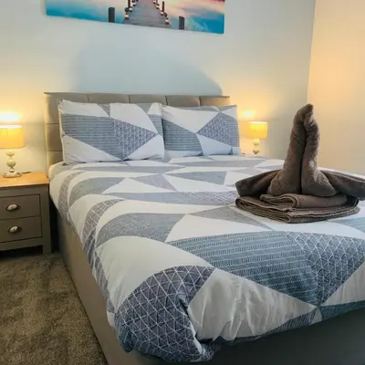 a bedroom with a bed with two animal slippers on it at The WhiteHouse Holiday Apartments in Blackpool