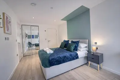 a bedroom with a bed with a blue comforter at 35 percent Off Stylish Liverpool Abode in Liverpool