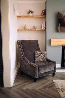 a chair sitting in a living room next to a wall at The Dunes, Lytham St Annes in Lytham St Annes