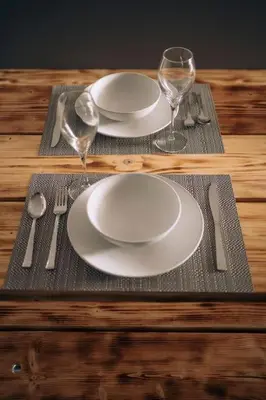 a table with two white plates and wine glasses at The Dunes, Lytham St Annes in Lytham St Annes