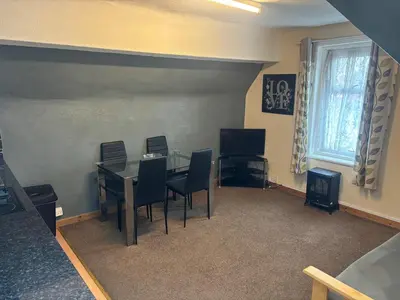 a dining room with a glass table and chairs at Phillips Apartments in Blackpool