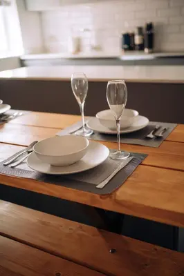 a wooden table with two plates and glasses on it at The Windmill, Lytham St Annes in Saint Annes on the Sea