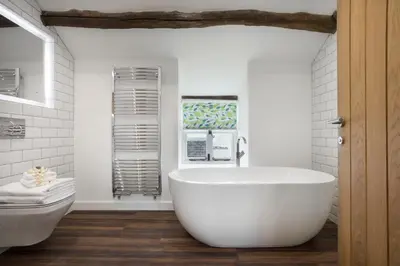 a bathroom with a large white tub and a toilet at Wharton House Mews in Cartmel, Lake District - Ridgestone in Cartmel