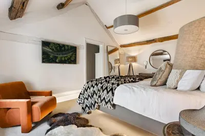 a bedroom with a bed and a chair at Wharton House Mews in Cartmel, Lake District - Ridgestone in Cartmel