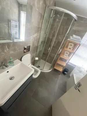 a bathroom with a sink and a shower and a toilet at The Pier Suite Serviced Apartment Blackpool in Blackpool
