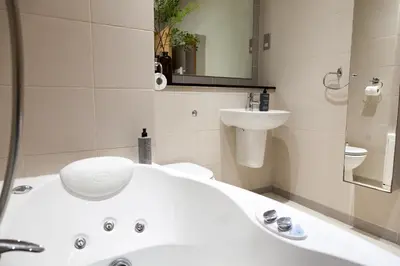 a bathroom with a white tub and a sink at Weekly & Monthly stays in Penthouse for Contractors or Leisure Single or Superking beds available in Birkenhead
