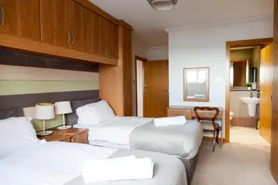 a hotel room with two beds and a bathroom at Weekly & Monthly stays in Penthouse for Contractors or Leisure Single or Superking beds available in Birkenhead