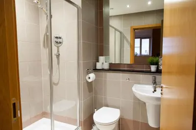 a bathroom with a shower and a toilet and a sink at Weekly & Monthly stays in Penthouse for Contractors or Leisure Single or Superking beds available in Birkenhead