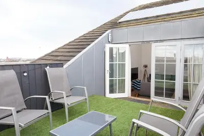 a patio with chairs and a couch on the grass at Weekly & Monthly stays in Penthouse for Contractors or Leisure Single or Superking beds available in Birkenhead
