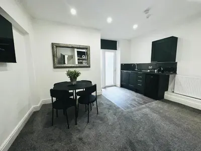 a kitchen with a table and chairs in a room at New osborne hot tub and jacuzzi suites in Blackpool
