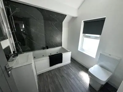 a bathroom with a sink and a toilet and a window at New osborne hot tub and jacuzzi suites in Blackpool