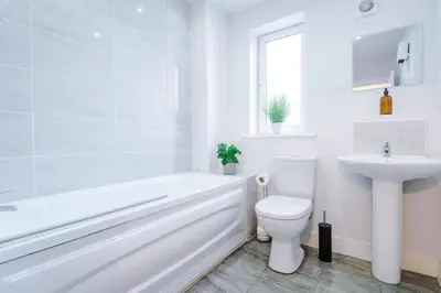 a white bathroom with a toilet and a sink at 1BR & 2BR Apt -for CONTRACTORS- free PARKING close to EVERTON & ANFIELD stadium, Liverpool City Centre managed by Chique Properties Ltd in Liverpool