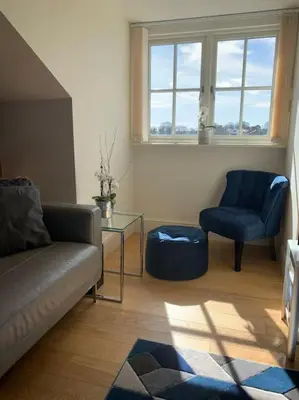 a living room with a couch and a table and two chairs at Stunning 3 Bedroom Penthouse in Ulverston Center in Ulverston