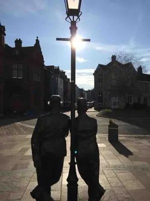 two statues are standing next to a light pole at Stunning 3 Bedroom Penthouse in Ulverston Center in Ulverston