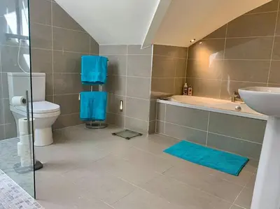 a bathroom with a toilet and a tub and a sink at Stunning 3 Bedroom Penthouse in Ulverston Center in Ulverston