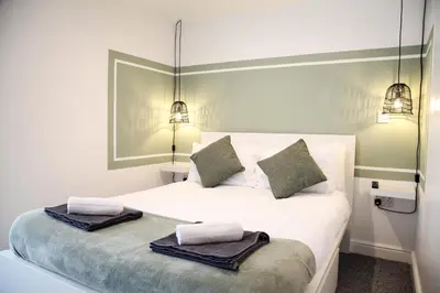 a bedroom with a white bed with two towels on it at City Centre short & long stay apartment in Liverpool