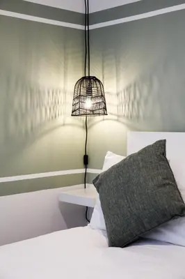 a bedroom with a bed with a bird cage on the wall at City Centre short & long stay apartment in Liverpool