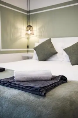 a bed with white sheets and a towel on it at City Centre short & long stay apartment in Liverpool