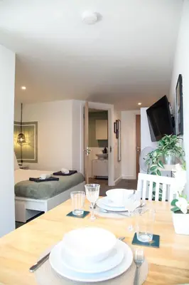 a dining room table with two white plates on it at City Centre short & long stay apartment in Liverpool