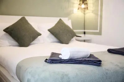 a white towel sitting on top of a bed at City Centre short & long stay apartment in Liverpool