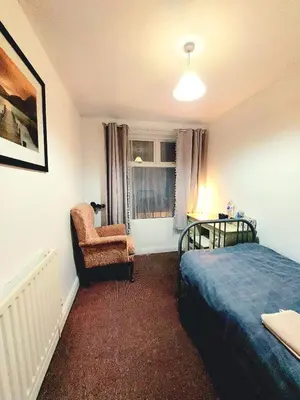 a bedroom with a bed and a chair and a window at Liverpool Newington Stay in Liverpool