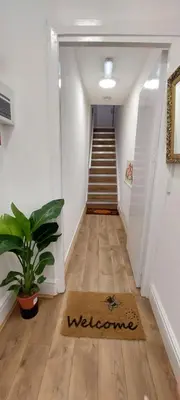 a hallway with a staircase with a welcome mat at Liverpool Newington Stay in Liverpool