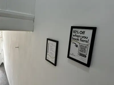 a wall with two framed signs on a wall at Charming Apartment Near Broad Green Hospital in Liverpool