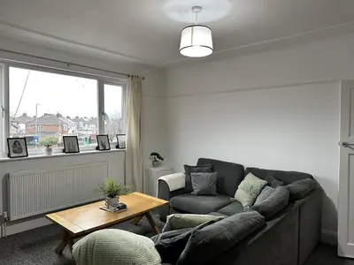 a living room with a couch and a table at Charming Apartment Near Broad Green Hospital in Liverpool