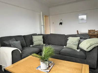 a living room with a gray couch and a table at Charming Apartment Near Broad Green Hospital in Liverpool