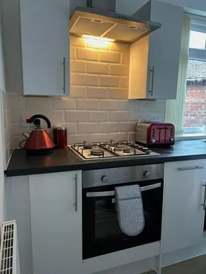 a kitchen with a stove top oven with a tea kettle at Charming Apartment Near Broad Green Hospital in Liverpool
