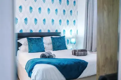 a bedroom with a large bed with blue pillows at Blackpool Lodge in Blackpool