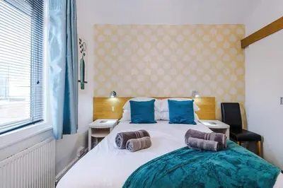 a bedroom with a large white bed with blue pillows at Blackpool Lodge in Blackpool