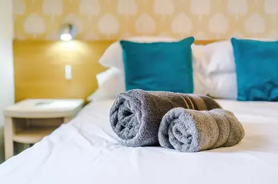 a pair of towels sitting on top of a bed at Blackpool Lodge in Blackpool