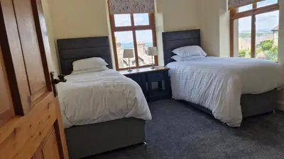 a bedroom with two beds and a window at Carr Garth in Arnside