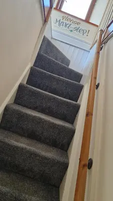 a staircase in a house with a sign on it at Carr Garth in Arnside